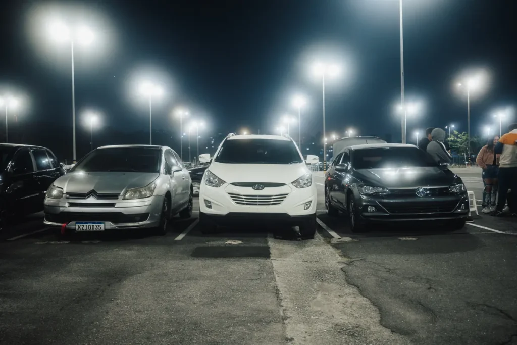Pensioner fined £70 over James Cook hospital parking fine after gridlock trap Night scene in a well-lit parking lot featuring various parked cars and street lamps