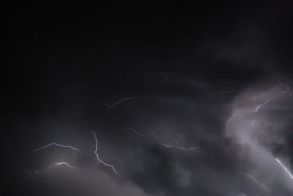 Intense lightning flashes illuminate a dark sky during a powerful thunderstorm